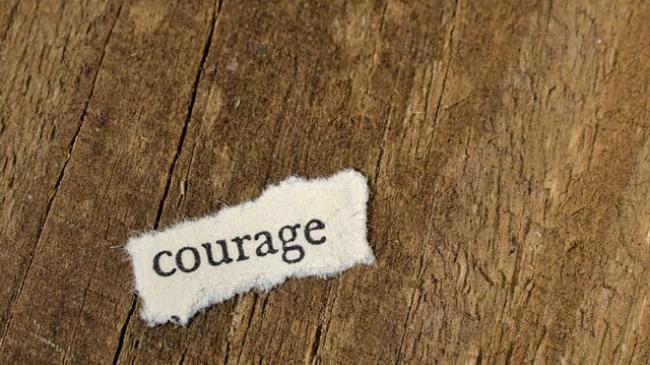 The word courage on a wood