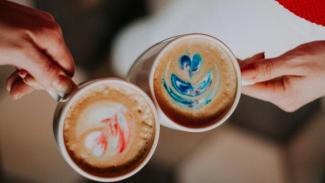 Two people holding coffee cups.